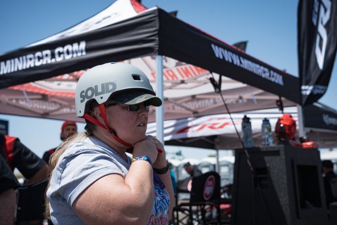 Tami Altergott takes a test drive on a MINI RCR Electric three wheeler at the Electrify Expo outside State Farm Stadium on May 4, 2024 in Glendale, Ariz.