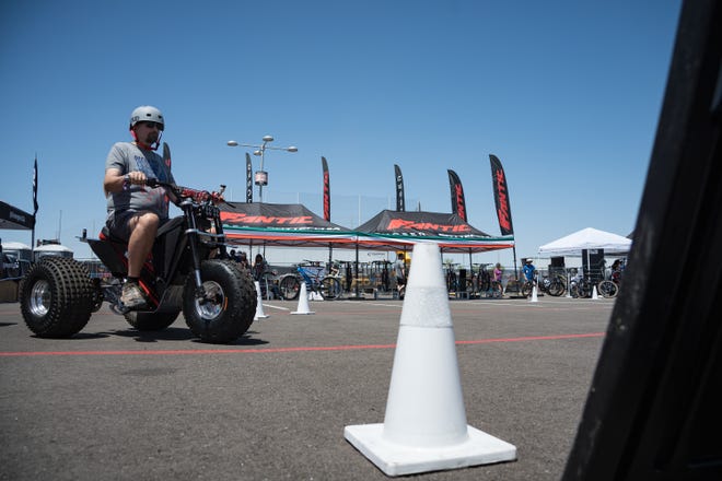 Randy Altergott takes a test drive on a MINI RCR Electric three wheeler at the Electrify Expo outside State Farm Stadium on May 4, 2024 in Glendale, Ariz.