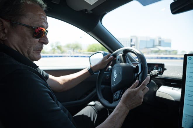 Professional driver, Andre Serra drives in one of Fordâ€™s â€œHot Lapsâ€ at the Electrify Expo outside State Farm Stadium on May 4, 2024 in Glendale, Ariz. Serra drives a Mustang Mach-E all electric SUV in a short stunt driving course.