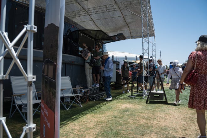 People gather around a model of the Lightship L1 electric travel trailer at the Electrify Expo outside State Farm Stadium on May 4, 2024 in Glendale, Ariz.