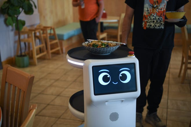 United Robotics Group's Plato service worker robot, nicknamed "Rosie" by owner Kultida Blais' young son, serves a noodle dish to a customer at Fai Thai in Knoxville, Thursday, May 23, 2024.