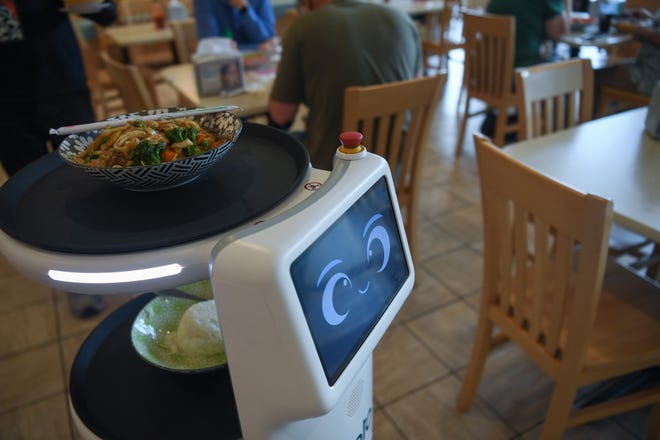 United Robotics Group's Plato service worker robot, nicknamed "Rosie" by owner Kultida Blais' young son, serves a noodle dish to a customer at Fai Thai in Knoxville, Thursday, May 23, 2024.