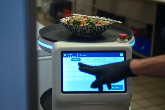 Owner Nathan Blais programs Rosie the robot to deliver food to a customer at Fai Thai in Knoxville, Thursday, May 23, 2024.