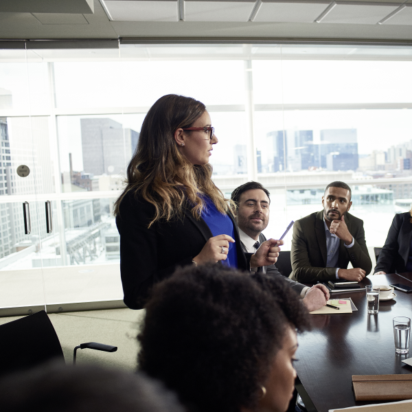 Person talking to a group of people in conference room.