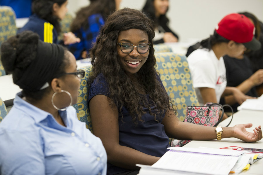 Two students smiling in class.