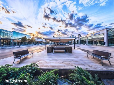 Modern and Urban Technology and Innovation Campus with outdoor employee square with benches, a wooden deck, a covered seating area, and buildings with 