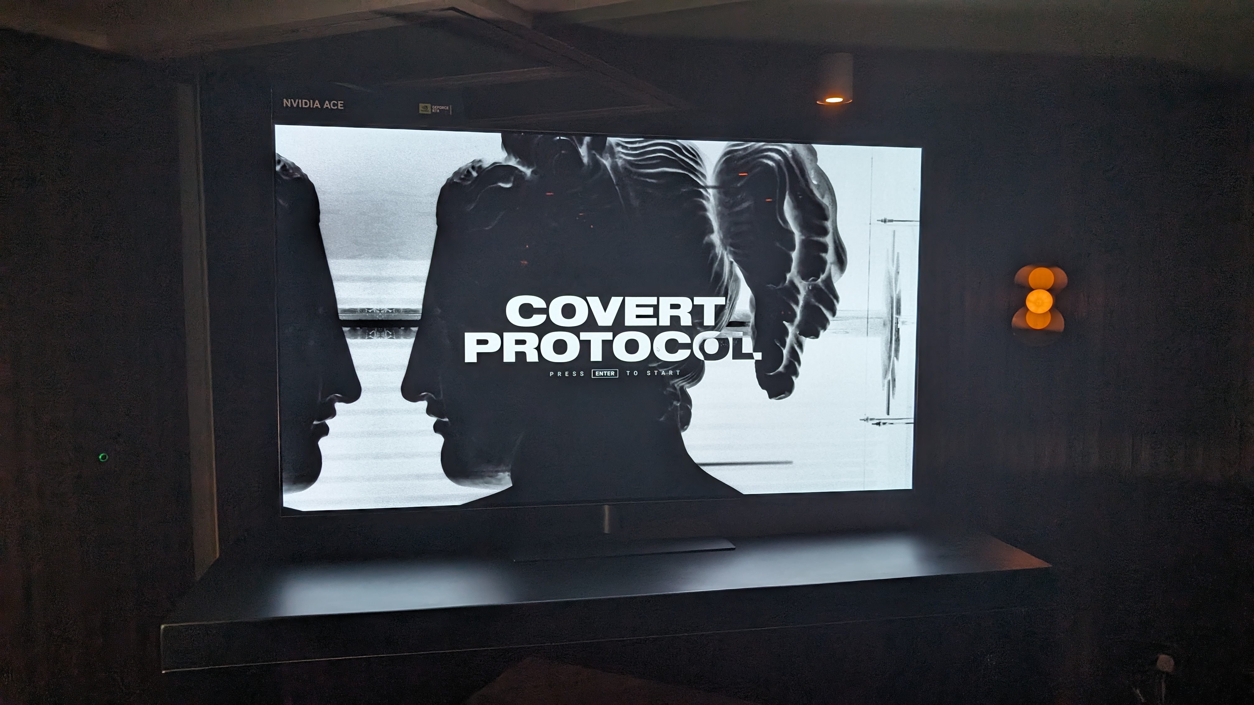 A photograph of a large TV displaying the Nvidia ACE 'Covert Protocol' demo.