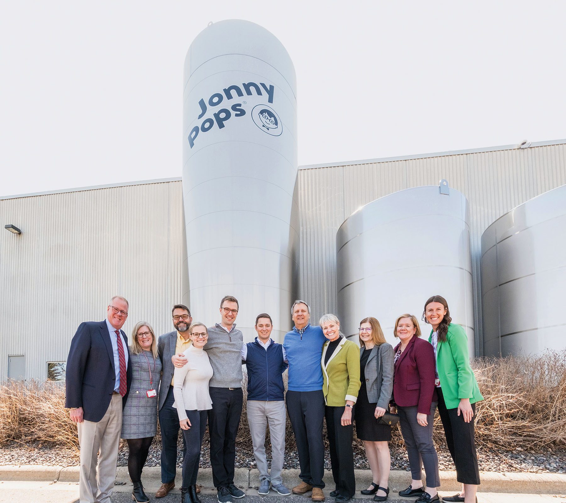 St. Olaf leaders toured the new JonnyPops facility this April. The group included (from left) Vice President for Enrollment and College Relations Michael Kyle ’85, Piper Center Director Kirsten Cahoon ’98, Vice President for Advancement Enoch Blazis, Sarah Beth Sivanich Brust ’13, Erik Brust ’14, Connor Wray ’14, Tom Brust ’80, Susan Brust ’80, St. Olaf President Susan Rundell Singer, Chief Marketing Officer Katie Warren ’95, and Piper Center Associate Director Meghan McMillan. Photo by Steven Garcia '20