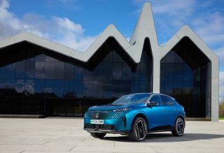 Peugeot E-3008 in front of concrete and glass building