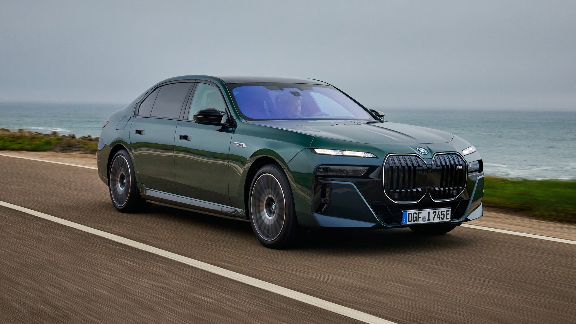 Front three-quarters action shot of a green BMW i7 M70 xDrive