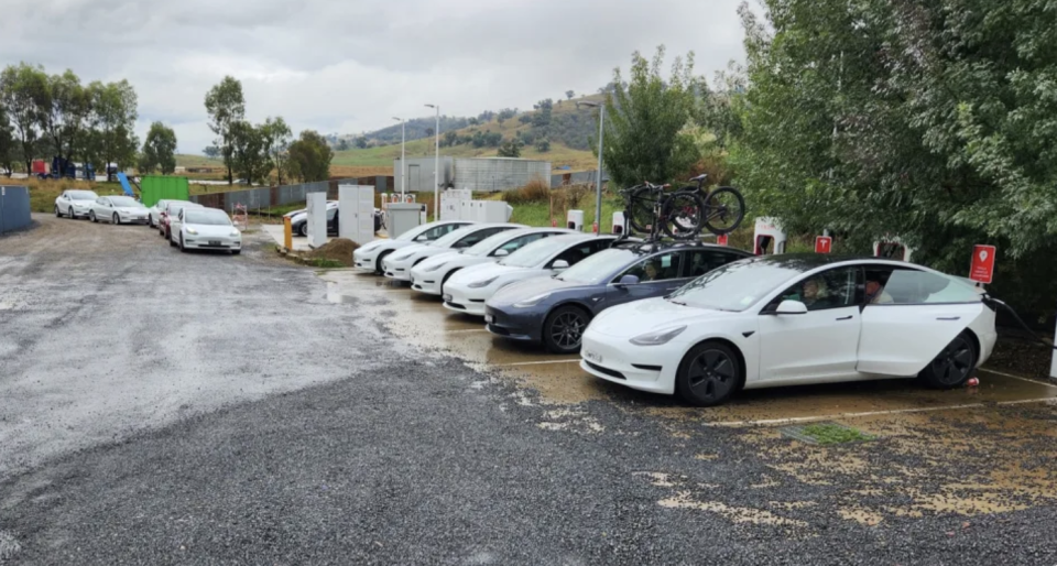 A queue of electric vehicles at a charging station. 