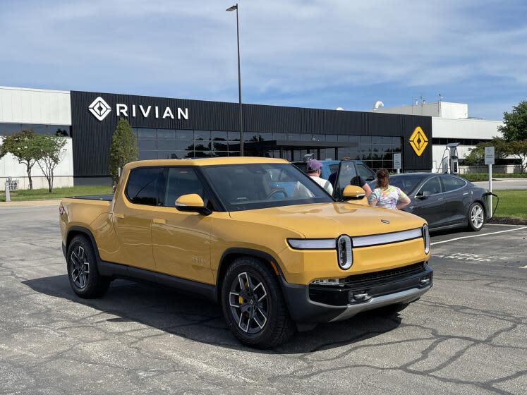 A family from Kentucky picks up a yellow Rivian truck at the Rivian factory in Normal, Illinois.