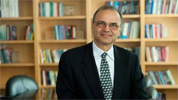 Farrokh Alemi in front of book shelves