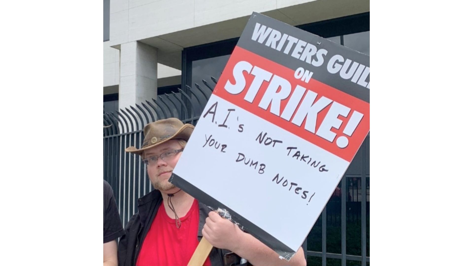 
A picketer at Universal City carries a sign deriding the proposals by film studios to replace writers with AI. 