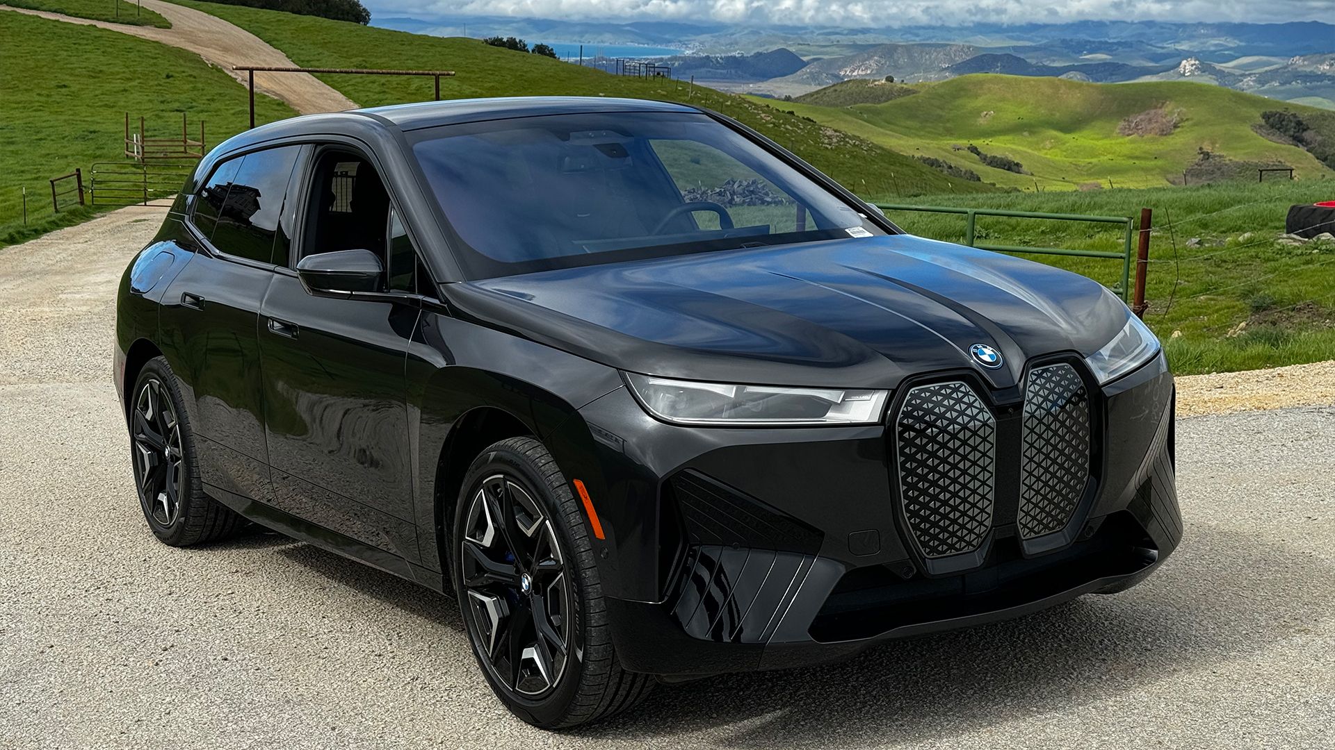 Front 3/4 view of 2024 black BMW iX