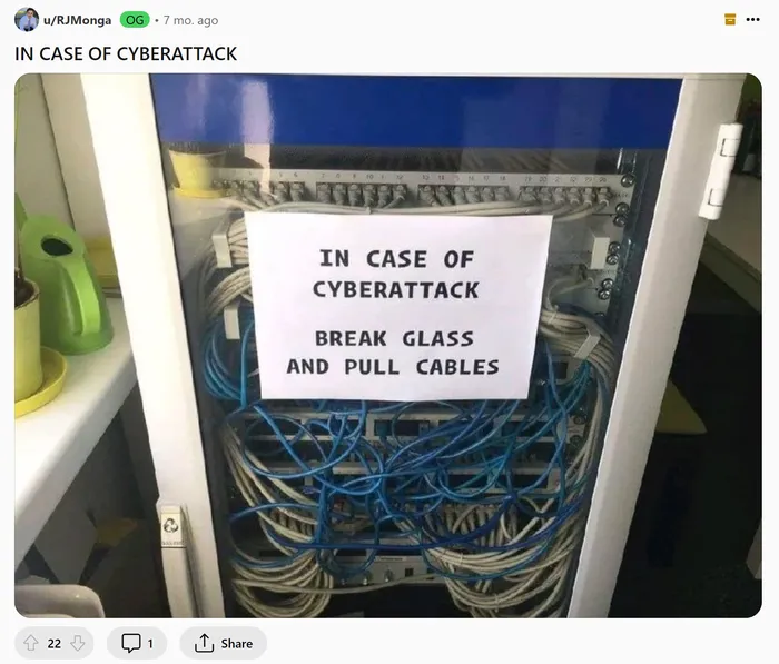 cybersecurity meme shows a box of complex wiring and a poster that says In Case of Cyberattack Break Glass and Pull Cables