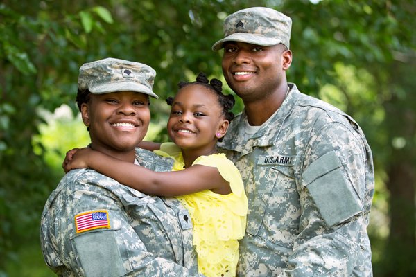 Military couple holding their child.