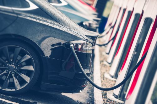 electric cars lined up at charging stations