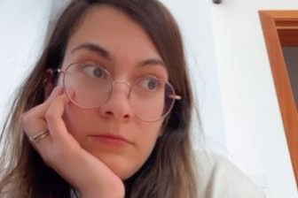 A screenshot of an Instagram video, featuring a woman with long, brown hair, wearing glasses.