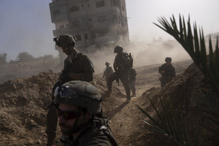 FILE - Israeli soldiers take up positions during a ground operation in Khan Younis, Gaza Strip on Jan. 10. 2024. An AP analysis of Gaza Health Ministry data finds the proportion of Palestinian women and children being killed in the Israel-Hamas war appears to have declined sharply. Israel faces heavy international criticism over unprecedented levels of civilian casualties in Gaza. (AP Photo/Ohad Zwigenberg, File)