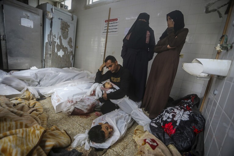 FILE - Palestinians mourn over the bodies of their relatives killed in the Israeli bombardment of the Gaza Strip in Deir al Balah, on April 10, 2024. An AP analysis of Gaza Health Ministry data finds the proportion of Palestinian women and children being killed in the Israel-Hamas war appears to have declined sharply. Israel faces heavy international criticism over unprecedented levels of civilian casualties in Gaza. (AP Photo/Ismael Abu Dayyah, File)