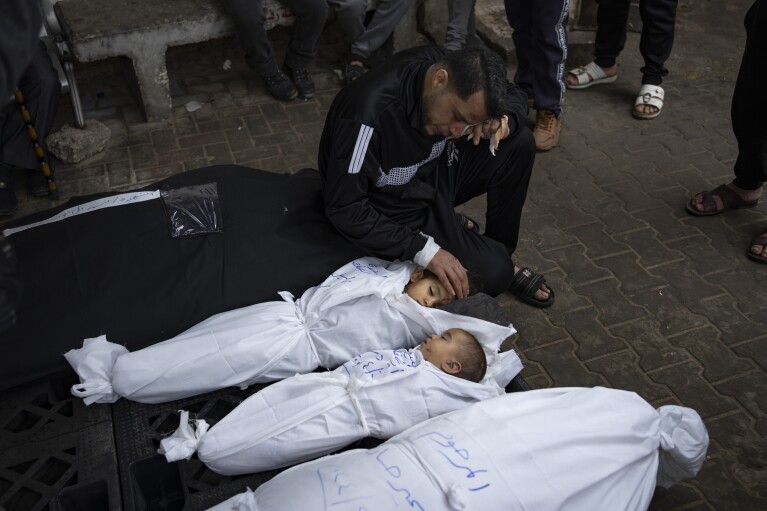 FILE - A man mourns over the bodies of his two daughters who were killed in the Israeli bombardment of the Gaza Strip, at a hospital morgue in Rafah, on April 4, 2024. An AP analysis of Gaza Health Ministry data finds the proportion of Palestinian women and children being killed in the Israel-Hamas war appears to have declined sharply. Israel faces heavy international criticism over unprecedented levels of civilian casualties in Gaza. (AP Photo/Fatima Shbair, File)