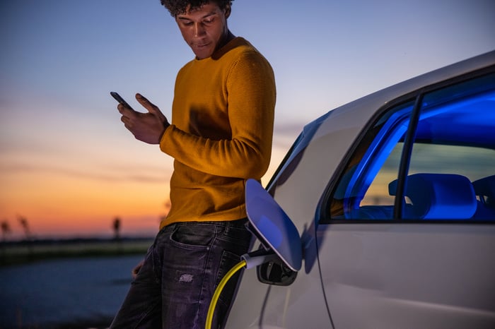 A person charges an electric vehicle.