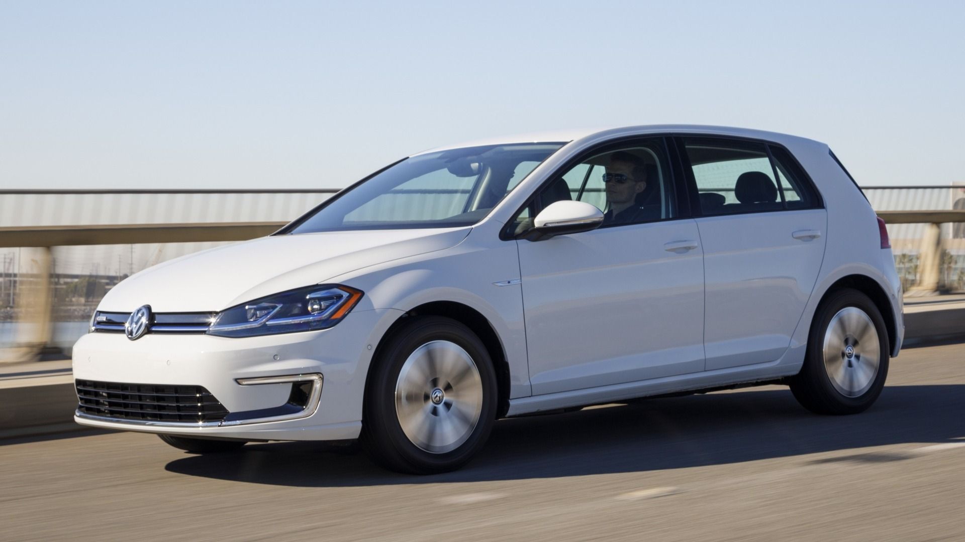 A white 2017 Volkswagen e-Golf on on overpass going at speed.