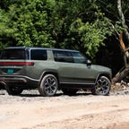 The all-electric 2022 Rivian R1S SUV looking cool in a light green and bright sunshine.