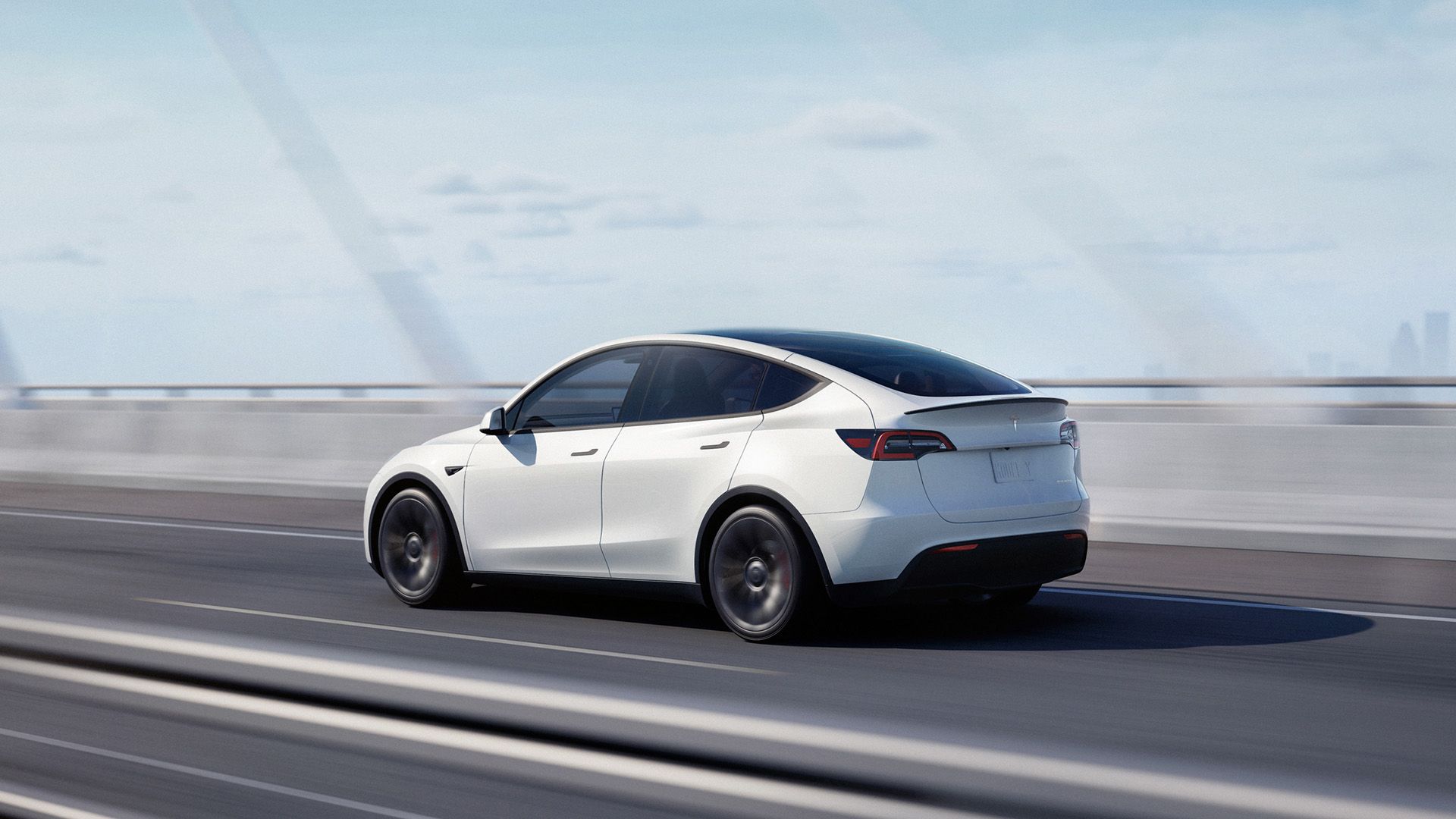 White Tesla Model Y cruising on the expressway. 