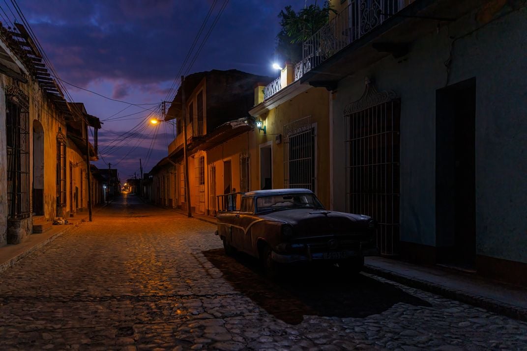 4 - A classic American car seemingly enjoys a night’s rest on a quiet street in the city of Trinidad.