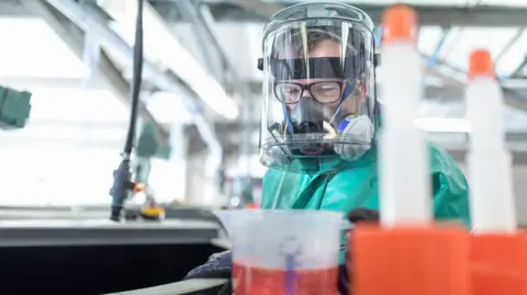 Getty Images Man preparing chemicals in factory