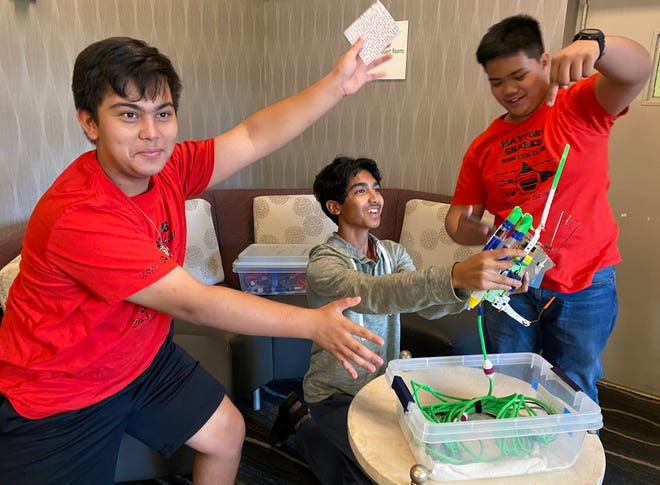 Darrell Keith J. Shelton, from left, Fazal Rehman and Raphael Ruiz show off their Mayport Coastal Science Middle School Robotics Team's entry in the international SeaPerch underwater robot competition.