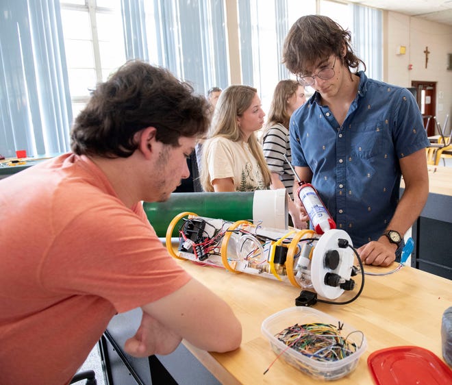 Catholic High School Robotics Team member Brandon Hoppe waterproofs an underwater submersible while teammate Luke Foster watches on Friday, June 14, 2024. The Catholic Robotic Club is preparing to travel to Tennessee for the MATE ROV world championship robotics competition.