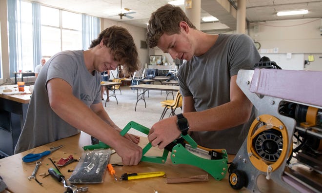 Catholic High School Robotics Team members Caleb Bobe and Ace London make final repairs and adjustments to an underwater submersible on Friday, June 14, 2024. The Catholic Robotic Club is preparing to travel to Tennessee for the MATE ROV world championship robotics competition.