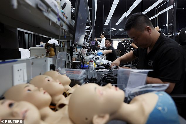 Employees are pictured constructing humanoid robots at the Ex-Robots factory in Dalian, Liaoning province, China