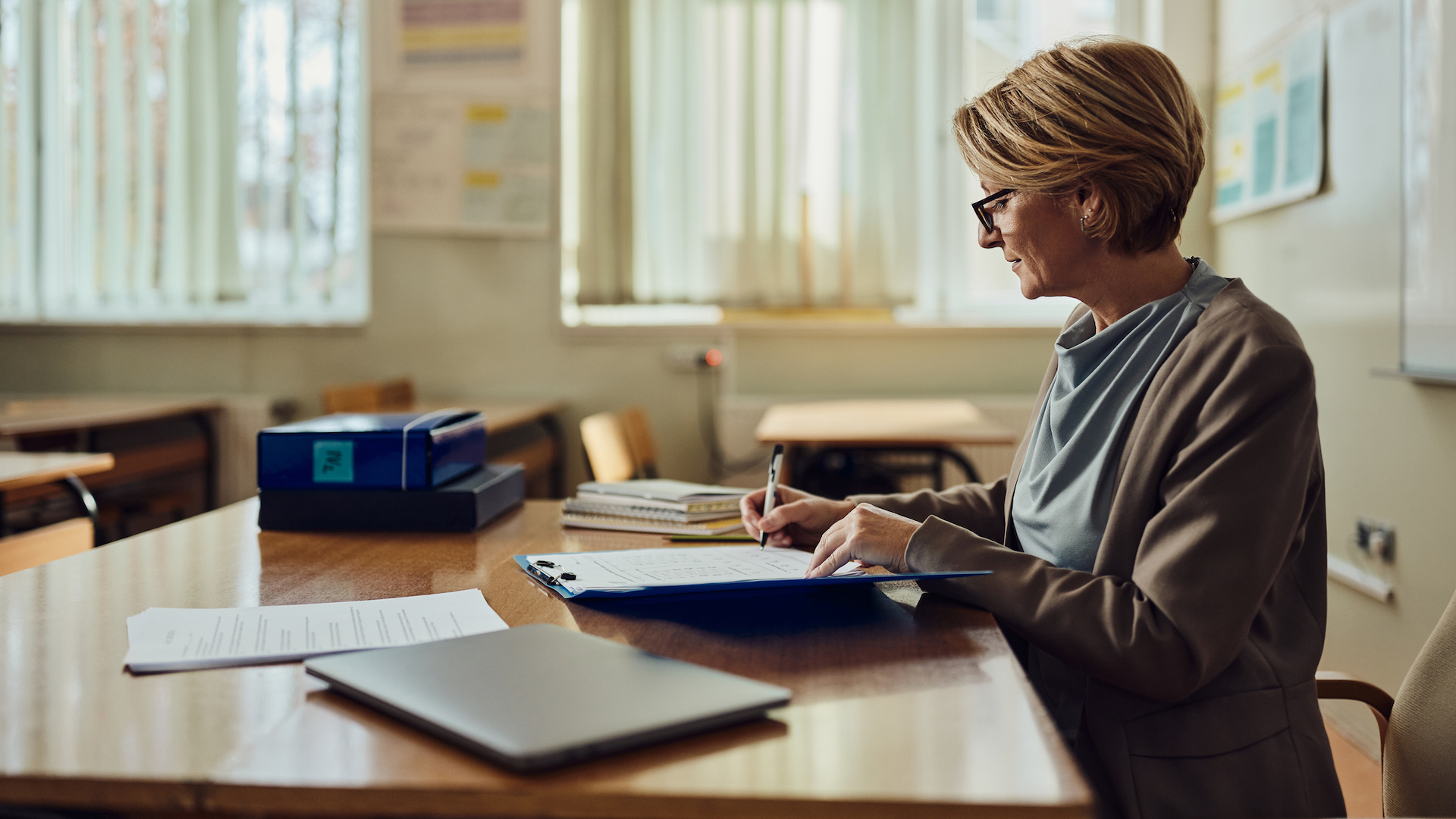 An older woman at a teacher's desk