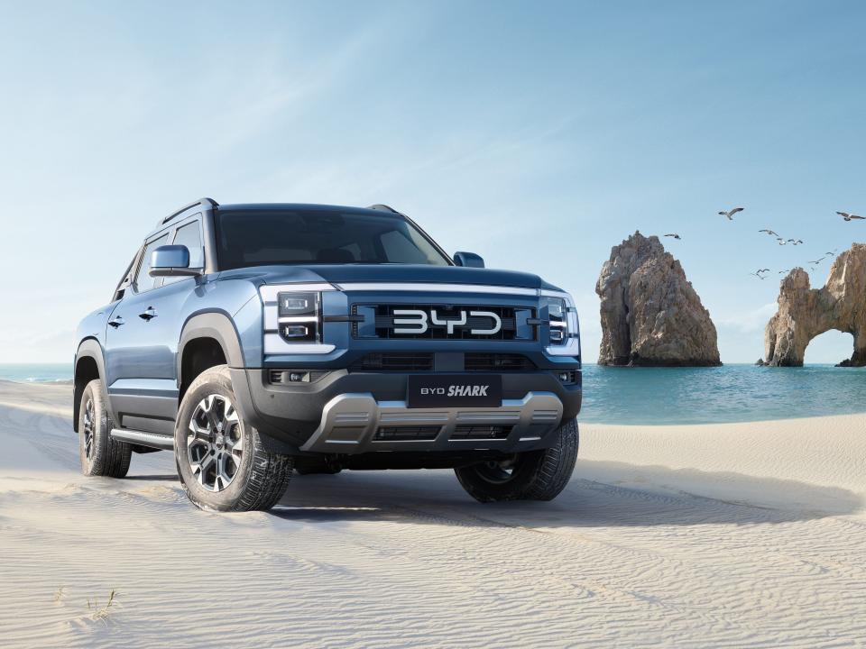 A blue BYD Shark pick-up truck parked on the breach.