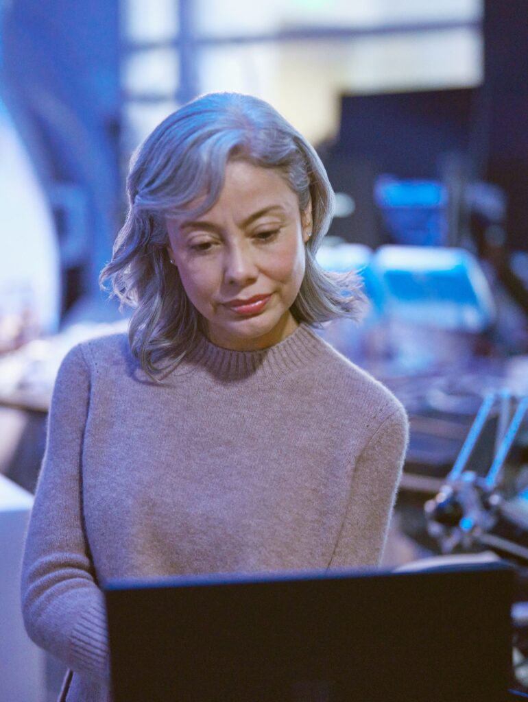 a woman standing in front of a laptop