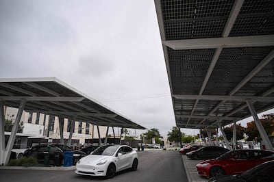 Tesla electric vehicles at EV charging stations beneath solar panels at a Tesla Supercharger site in Santa Monica, California. AFP