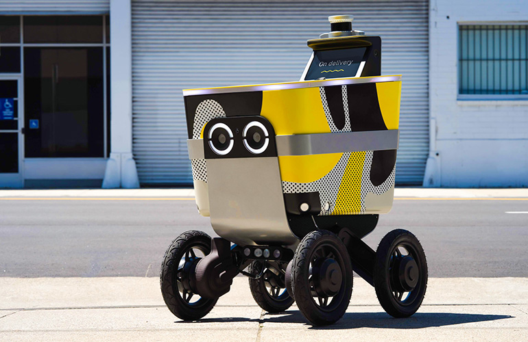 Serve Robotics' yellow, gray, and black autonomous delivery robot outdoors on a street. 