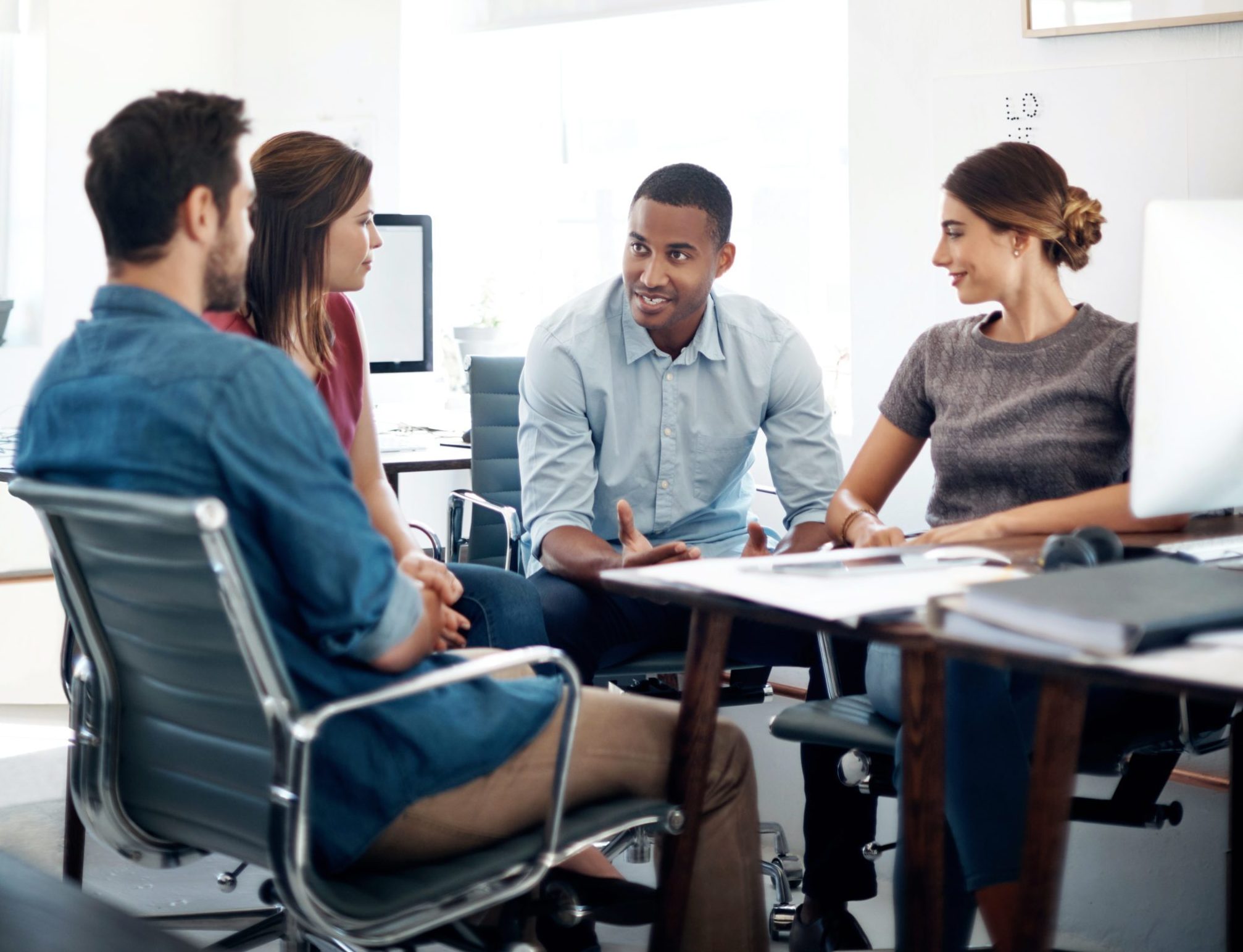 Office workers in discussion at conference table