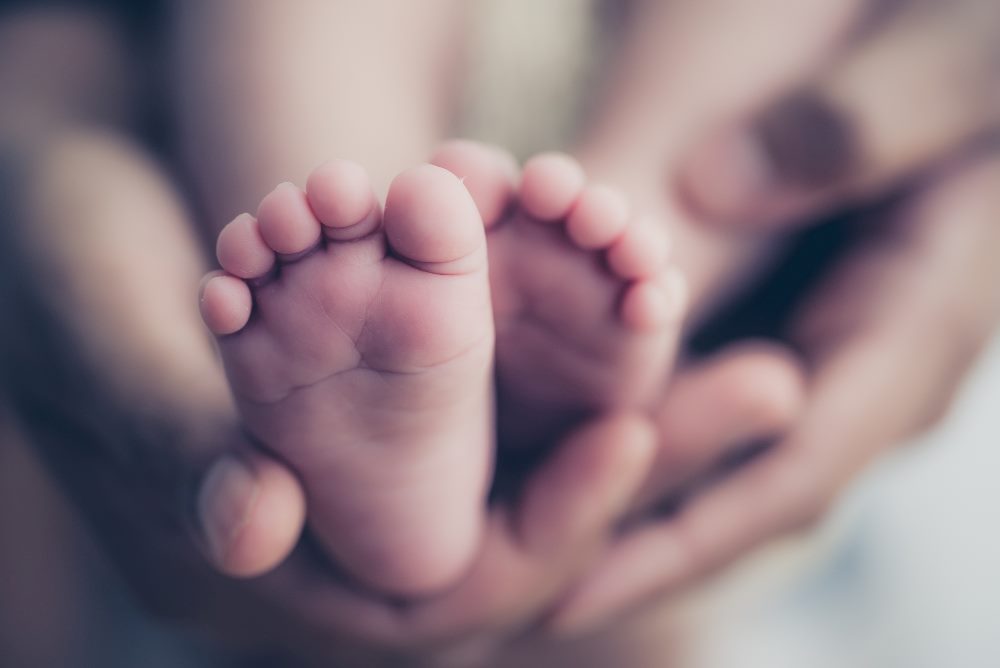 Feet of a newborn baby in the hands of parents, suggesting the birth of data product and data product management.