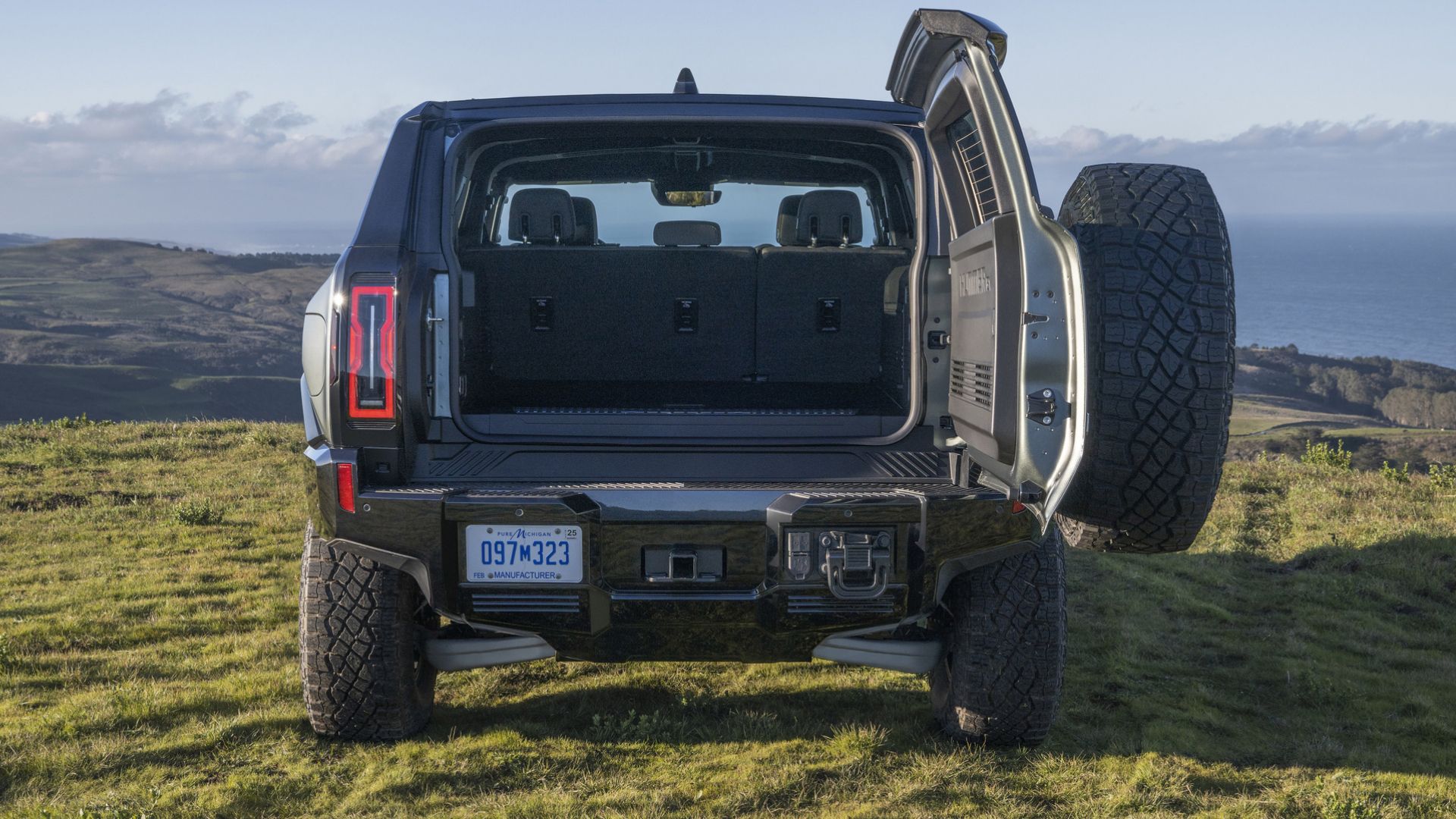 2024 GMC Hummer EV rear tailgate view posing in field