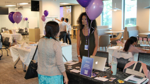 person talking to another person at a display table