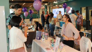 person talking to others at a display table