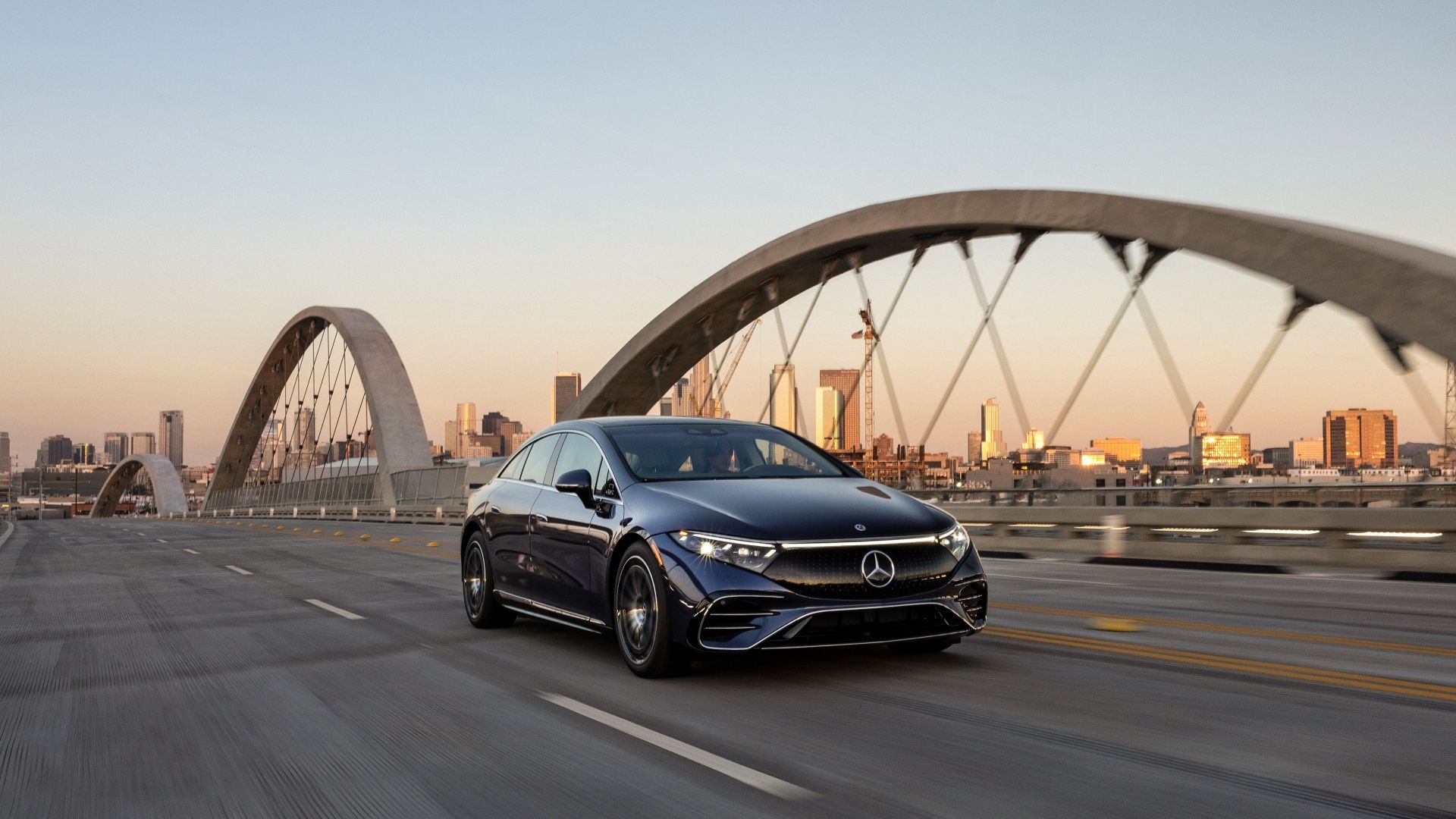 Mercedes EQS Driving on a bridge with a city in the distance